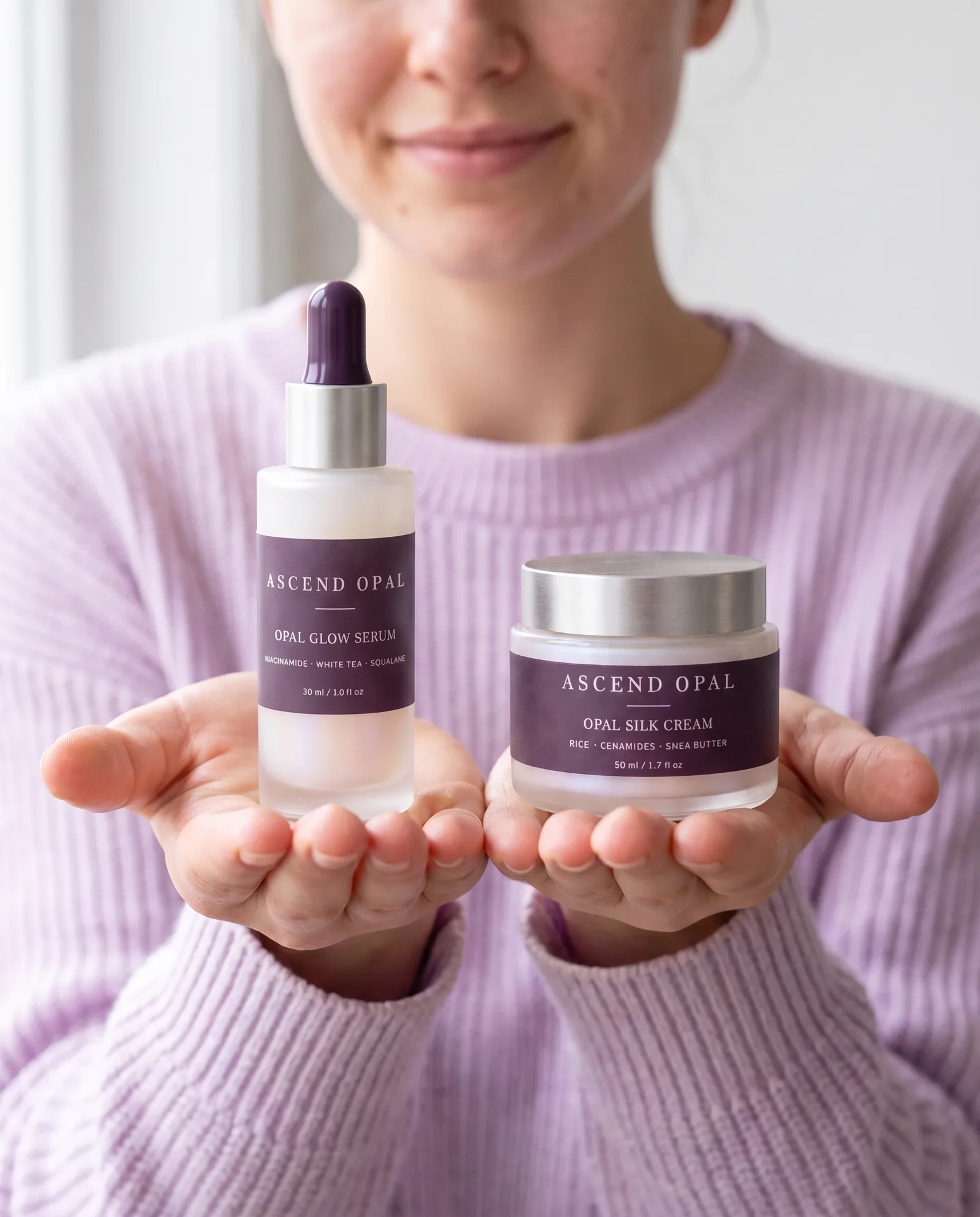 Two hands held out toward the camera holding Opal Glow Serum and a jar of Opal Silk Cream